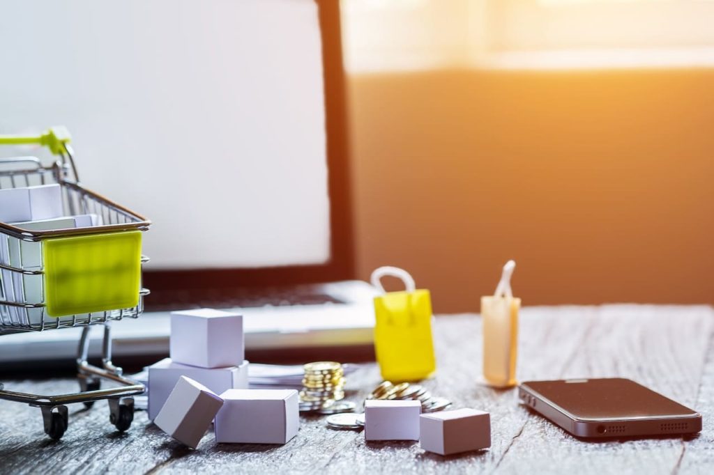 caddie miniature devant un ordinateur ouvert sur un site e-commerce