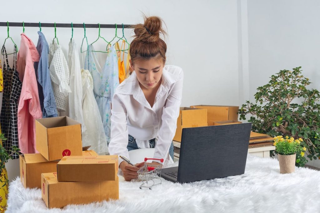 femme en train de preparer des commandes pour sa boutique de vêtement en ligne